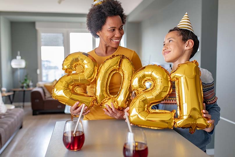 Woman and son celebrating with 2021 gold balloons