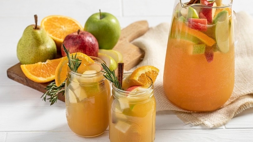 Autumn Harvest Punch, mason jar glasses, pitcher, cutting board , fresh fruit, napkin, white wood table