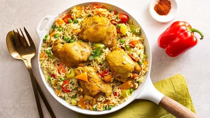 Arroz Con Pollo in pan, napkin, bell pepper, paprika, spoon, fork