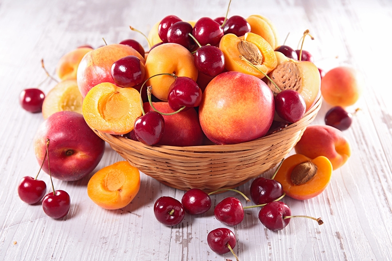 Wicker Bowl of assorted Stone Fruits, cherries, peaches, apricots and nectarines