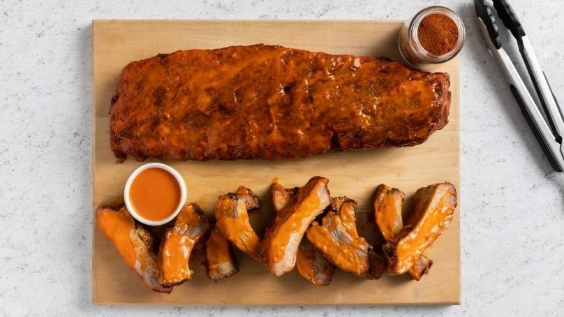 Tender Grilled Buffalo-Style Ribs, cutting board, Buffalo sauce, tongs