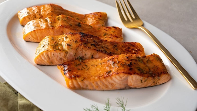 Caramel Glazed Salmon with Brown Sugar, white plate, brass fork, light contertop