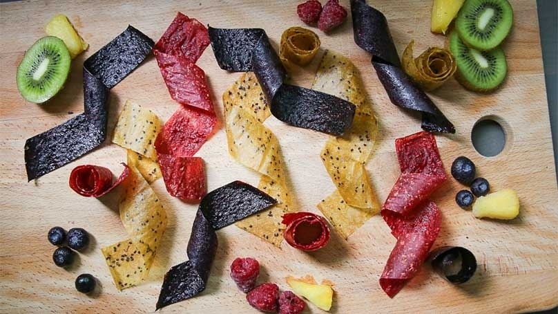 Homemade Fruit Rolls, sliced kiwis, raspberries, blueberries, pinapple chuncks, wood table